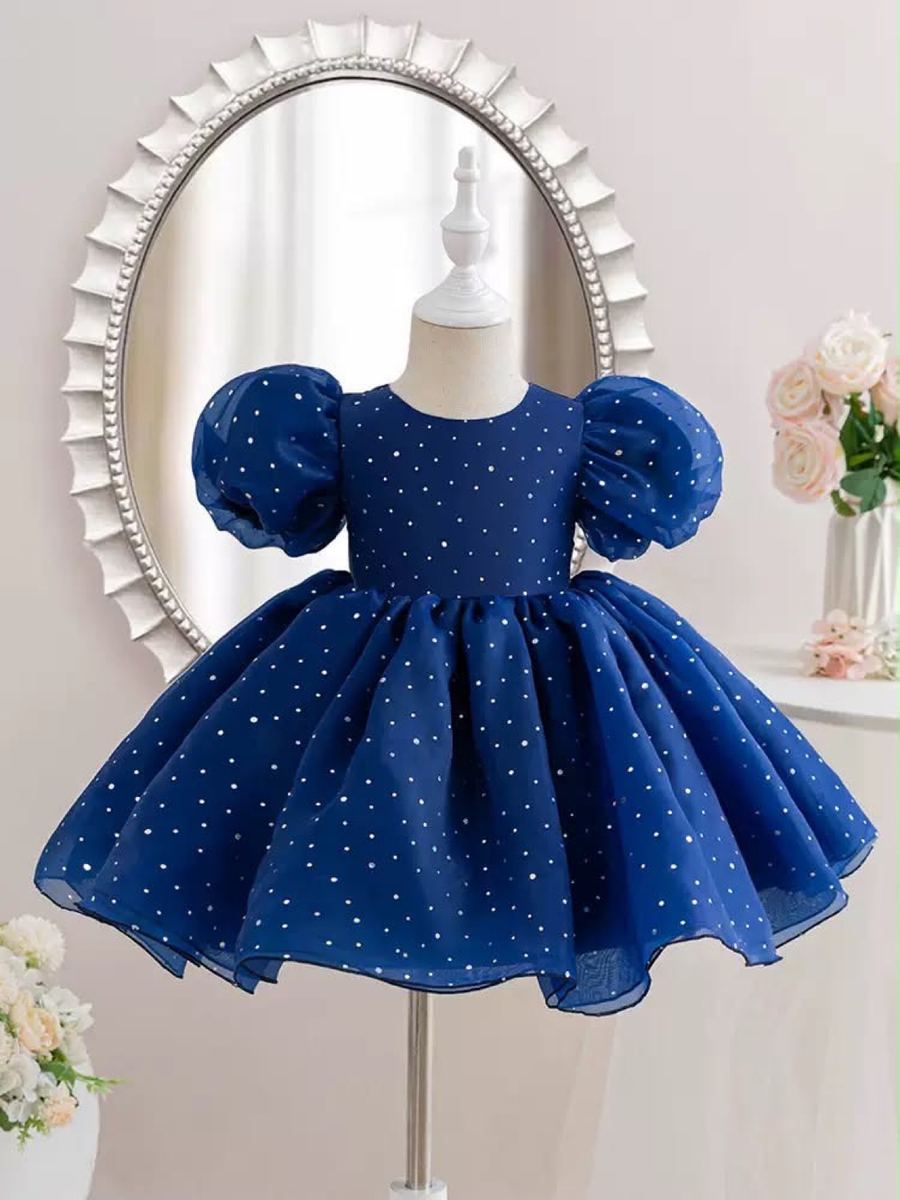 A navy dress with white dots on a stand.