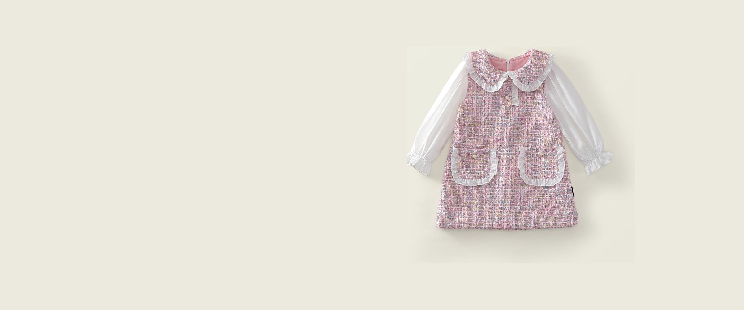 The Mabel Dress, a pink tweed pinafore and white blouse, laid flat.