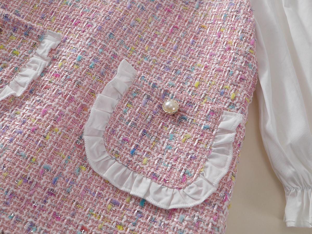 The Mabel Dress, a patch pocket with a ruffled edge and a pearl button.